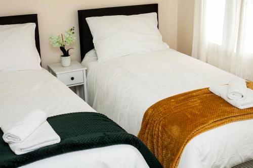 纽尼顿Avril Warwickshire Home Stay的一间卧室配有两张带毛巾的床