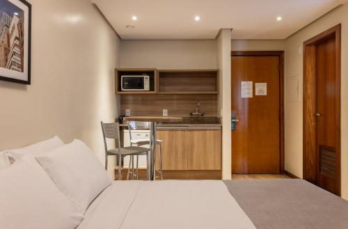 阿雷格里港阿雷格里港千禧蓝树酒店的酒店客房带一张床和一个厨房