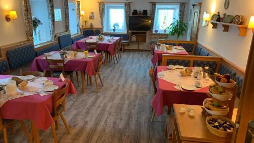 柯尼希斯湖畔舍瑙格莱克里宾希酒店的一间设有红色桌布的餐桌的用餐室