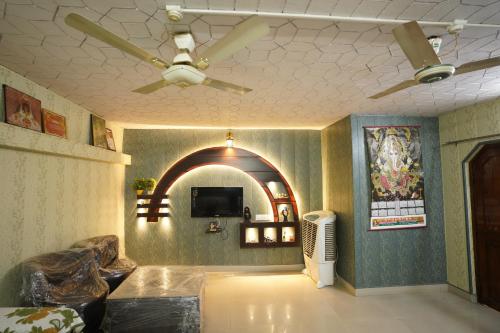 瓦拉纳西Kashi dham Homestay ( close to Kashi Vishwanath temple and Ghats)的客厅配有吊扇和电视。