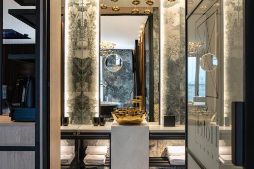 克拉科夫Art Suites Luxury Hotel的更衣室配有镜子和水槽