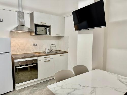 里米尼Residence Rimini Relax的厨房配有白色橱柜和桌椅