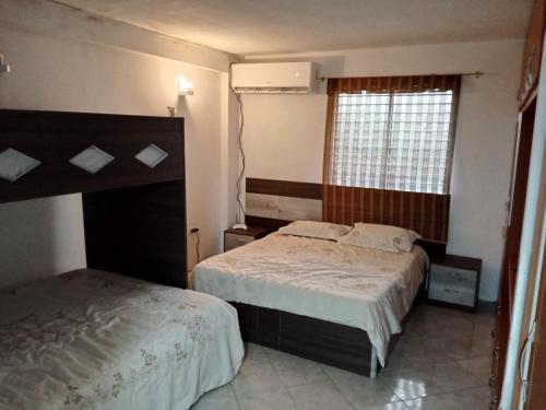 El Morro de BarcelonaApartamento playero en Lecheria的一间卧室设有两张床和窗户。