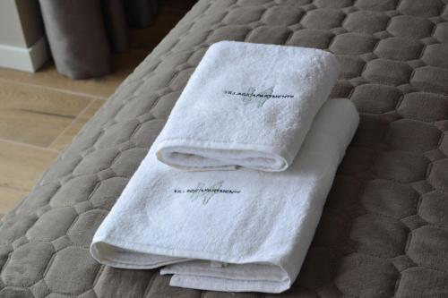 波利亚纳Village apartments Polyana的床上的两条毛巾