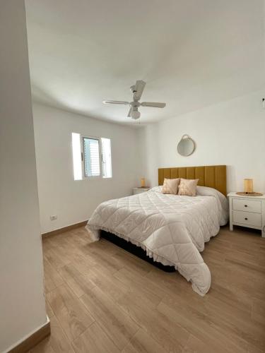 卡门港Bungalow Ara的白色卧室配有床和吊扇