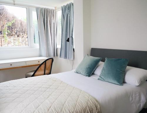 CantleyComfortable and cosy house with off-road parking的一间卧室配有一张带蓝色枕头的床和一扇窗户。