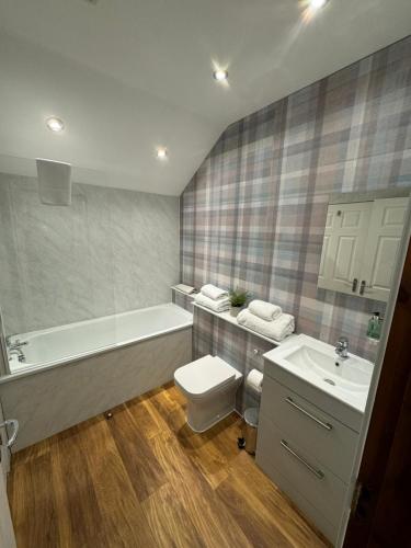威廉堡1 Sheraton Apartments的带浴缸、卫生间和盥洗盆的浴室