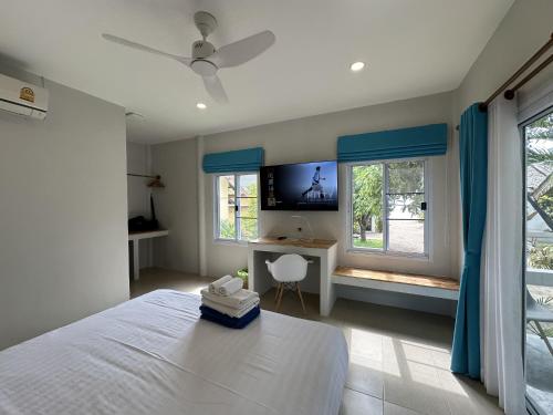 班泰Sand Terrace Beach Bungalows的卧室配有一张床、一张书桌和窗户。