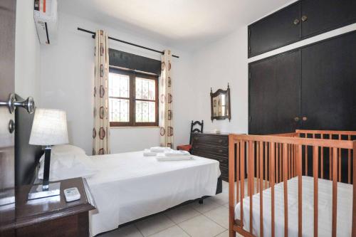 维拉摩拉Villa Vistagolf的一间卧室配有一张床和一张婴儿床