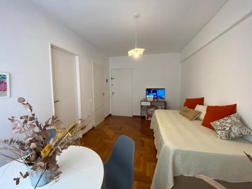 布宜诺斯艾利斯Apartamento Carlota的客房设有两张床、一张桌子和一台电视机。