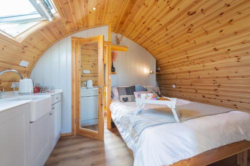GalstonThe Stag Pod Farm Stay with Hot Tub Sleeps 2 Ayrshire Rural Retreats的小房间,设有木制天花板上的一张床铺