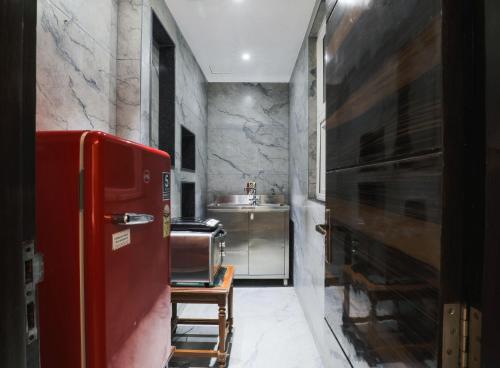 新德里Cosy Grand, Near Chanakyapuri, Embassy Area的厨房配有红色冰箱和水槽