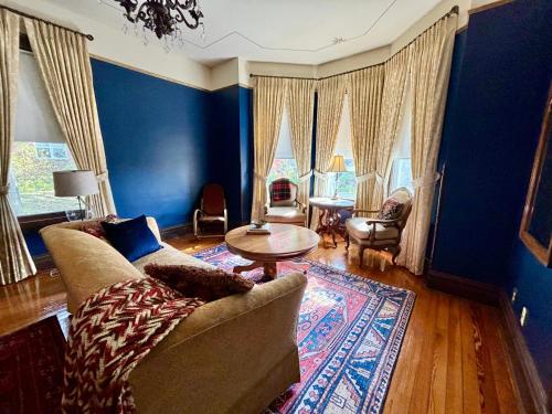 开普吉拉多MacFie House的客厅设有蓝色的墙壁、一张沙发和一张桌子