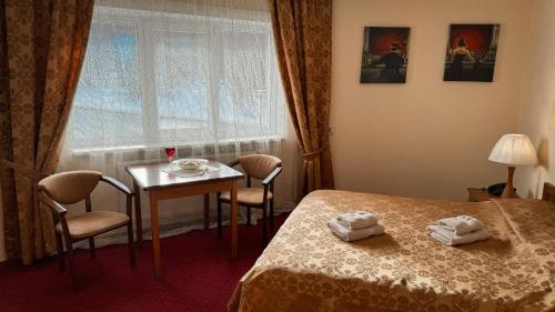 捷尔诺波尔Geneva Hotel的客房设有床、桌子和窗户。