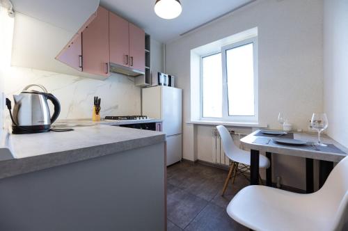 基辅Квартири метро Дарниця світло завжди є的厨房配有白色冰箱和桌椅