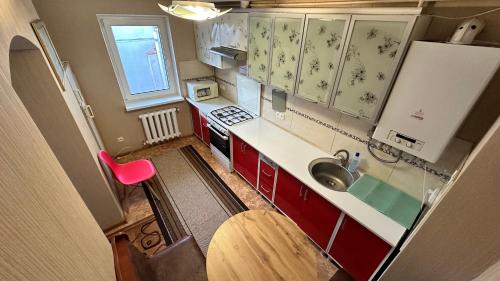 尼古拉耶夫Отель "Natali"的一个带红色橱柜和水槽的小厨房