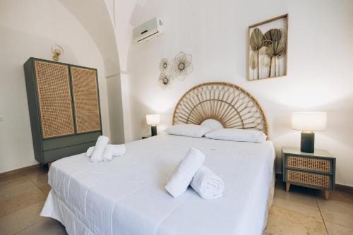 普尔萨诺Dalila Apulian Rental Rooms的一间卧室配有带白色床单和毛巾的床。