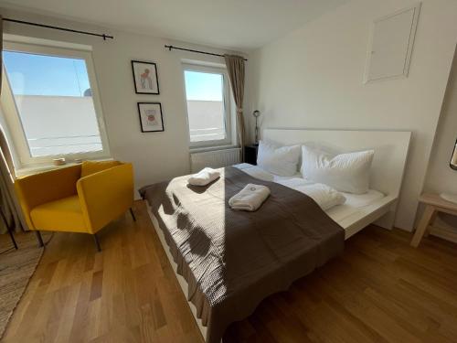 HohenweilerMaurerhaus Studio, Top 5的一间卧室配有一张带黄椅的床和两个窗户