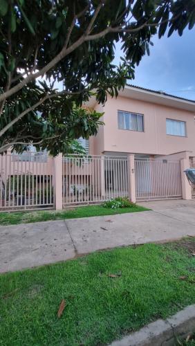 锡诺普Sobrado privativo com suite的粉红色的房子,前面有栅栏
