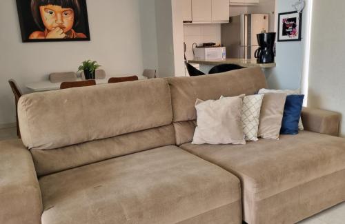 锡诺普Sobrado privativo com suite的客厅配有带枕头的棕色沙发
