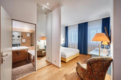 维也纳昆斯托弗酒店的酒店客房,配有床和镜子