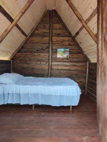 SapopemaPousada 4 estações/chalés的木制阁楼卧室配有一张床