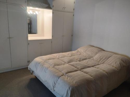 乌斯帕亚塔Altos Penitentes Lomas Blancas, dúplex的一间卧室配有一张带镜子和白色橱柜的床。