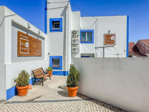 塞卡尔Solar do Alentejo的拥有蓝色和白色墙壁和盆栽植物的建筑