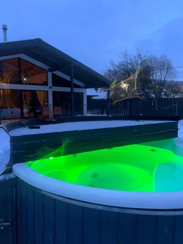 斯拉夫西克Boiko house的房屋前方的带绿色照明的热水浴池
