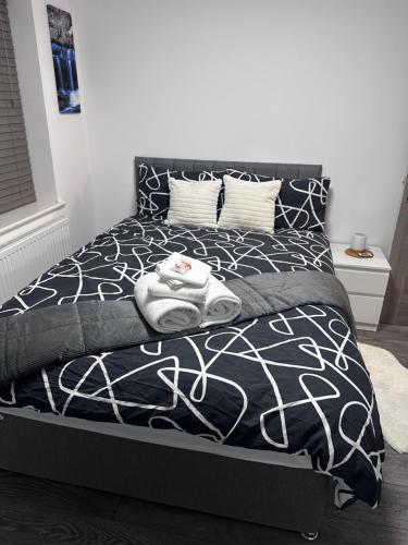 莱斯特Stunning 2-flat in Leicester!的一张带黑白棉被和枕头的床