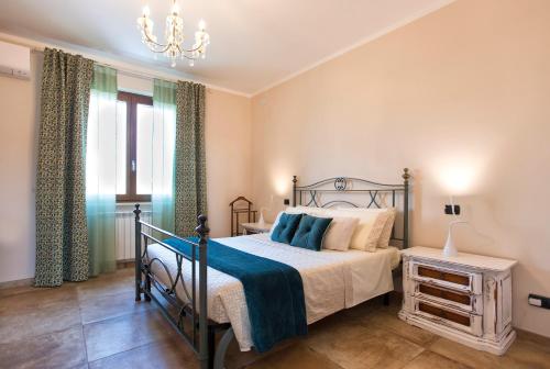 萨萨里Villa Malvasio Retreat & Spa的一间卧室配有一张床和一个吊灯