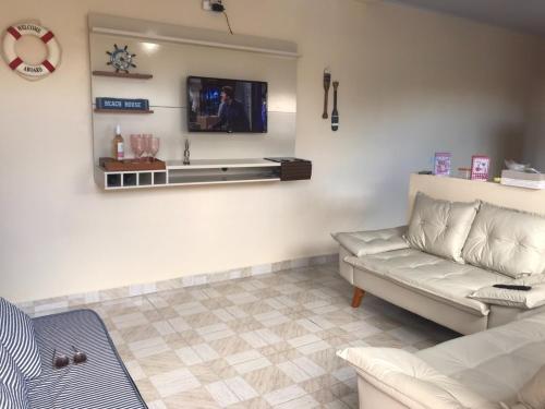 伊塔尼亚恩Doce Refugio Itanhaém的客厅配有沙发和墙上的电视