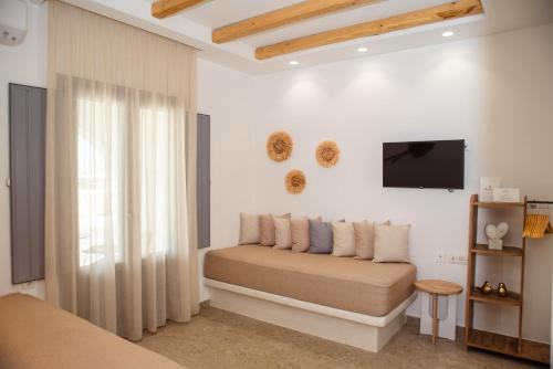 圣安娜纳克索斯Anais Of Naxos的一间带沙发和电视的墙壁卧室