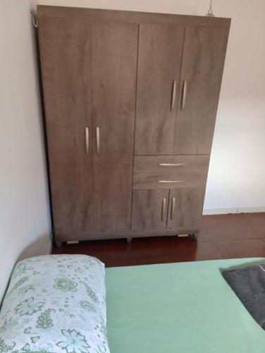 PalmasTedesco的一间卧室配有木制橱柜和一张床