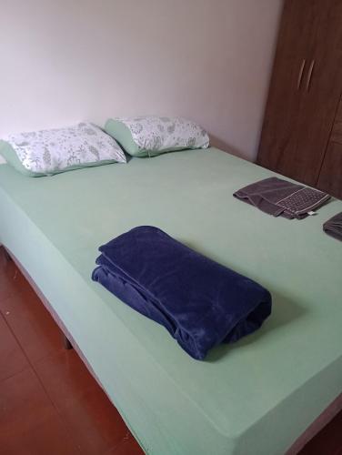 PalmasTedesco的两张带蓝色床单和枕头的床