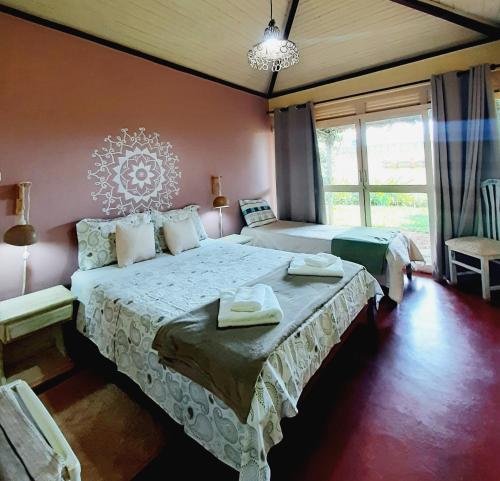戈亚斯州上帕莱索Pousada Paralelo 14的一间卧室设有两张床和大窗户