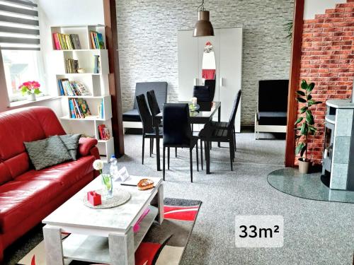 赖兴巴伊姆福格特兰Ferienwohnung "Blick Mylau" - Nähe Freizeitpark Plohn & Göltzschtalbrücke的客厅配有红色的沙发和桌子