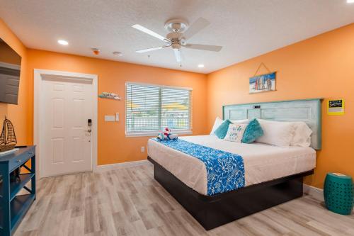 圣徒皮特海滩The Lofts at St Pete Beach的一间卧室设有橙色的墙壁和一张带天花板的床。