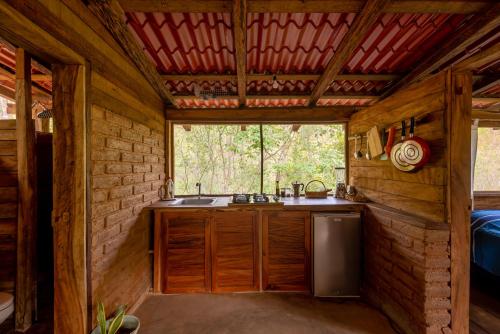 Santa María HuatulcoYoo'Nashi - Estancia Ecológica y Experiencias Comunitarias的小木屋内的厨房,配有水槽和窗户