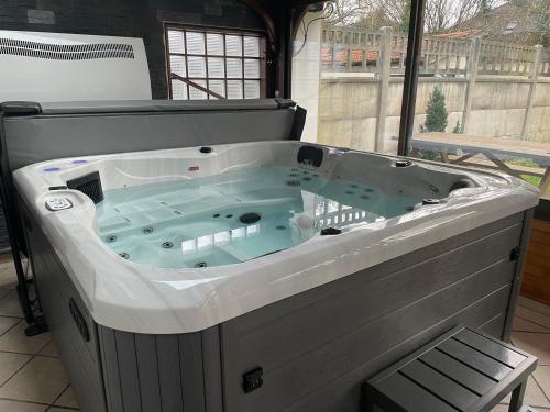 维勒班特Appt privé, Jaccuzi pro, 2 pers, 100m2, jardin, proche, Parc des Expositions, Aéroport CDG, Villepinte的一个带椅子的客房内的按摩浴缸