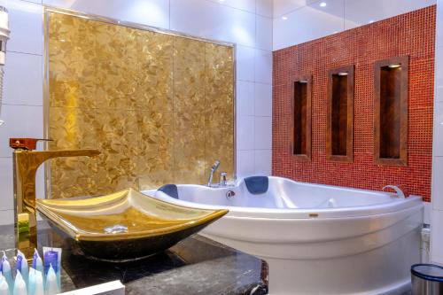 麦地那Nersyan Taiba Hotel Apartments的一间带大浴缸和水槽的浴室