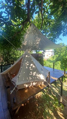 卡佩斯特雷贝勒奥Tipi/Glamping的坐在树下野餐桌上的帐篷