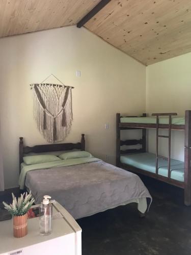 圣罗克迪米纳斯Chalé da Mata的一间卧室设有两张双层床和一张桌子