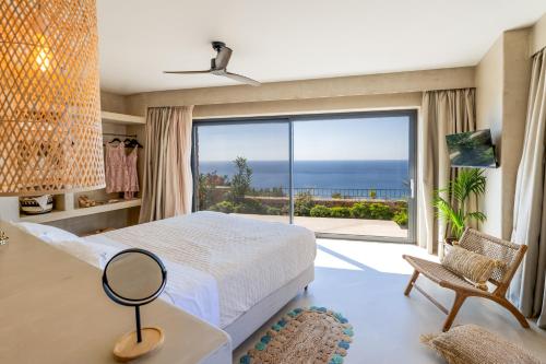 凯法利尼亚岛Apeiron Villas的一间卧室配有一张床,享有海景