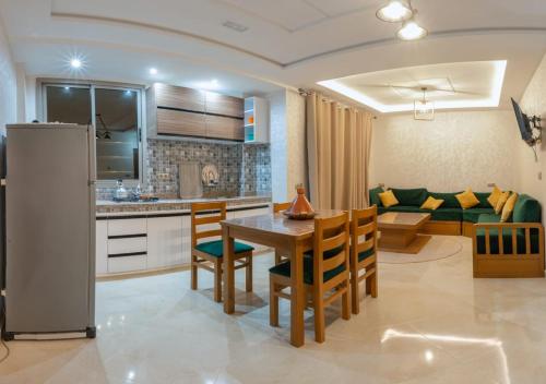 依索安Malak House的厨房以及带桌椅的起居室。