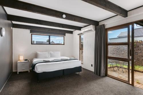 泰晤士Rolleston Motel Thames - Wenzel Motels的一间卧室设有一张床和一个窗口