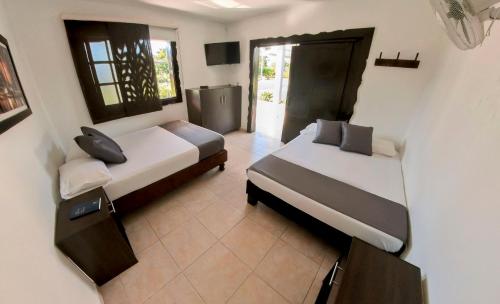 亚美尼亚Finca Hotel Palmas Del Edén的一间卧室配有两张床和电视。