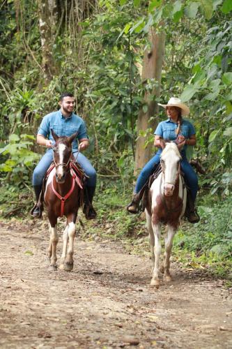 福尔图纳Chachagua Rainforest Hotel & Hot Springs的两个人在土路上骑马
