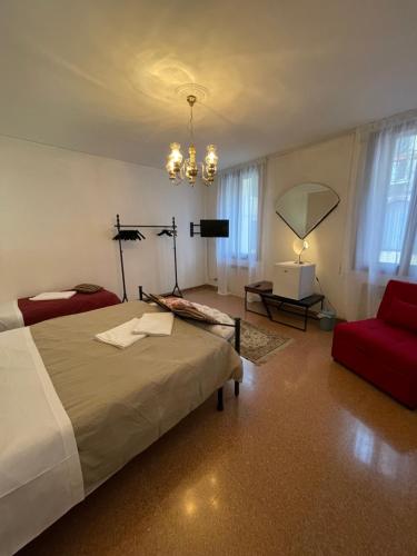 威尼斯Lions Venice Guest house的一间卧室配有一张床和一张红色椅子