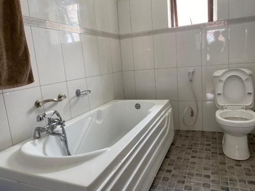 AruaMissions Cafe Arua - GuestHouse的白色的浴室设有浴缸和卫生间。